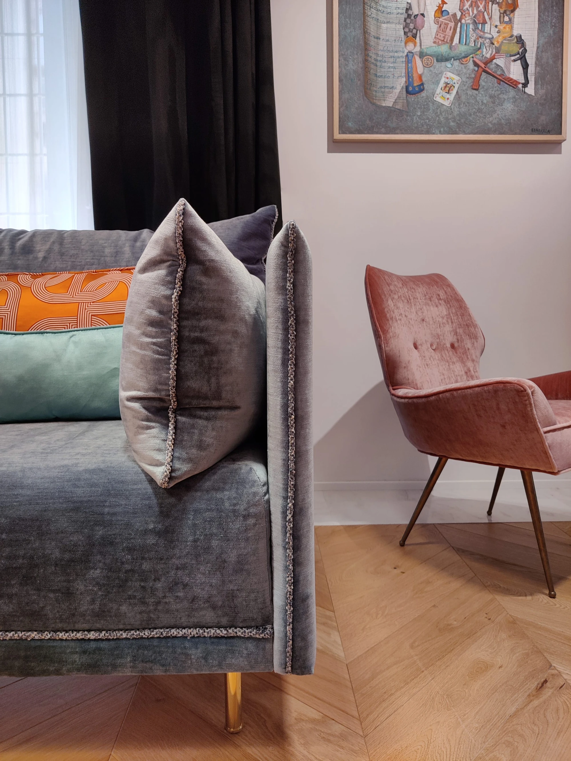 Living LC Apartment: divano in velluto grigio con cuscini in seta arancio e celeste, poltrona in velluto rosa ispirata agli anni '50 e parquet a spina di pesce